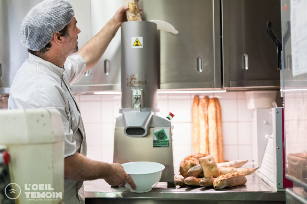 Un boulanger utilisant le broyeur a pain Crumbler